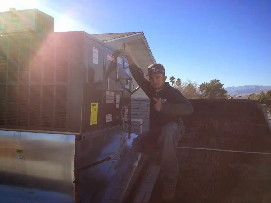 HVAC technician performing HVAC Inspection on a rooftop unit in Piedmont