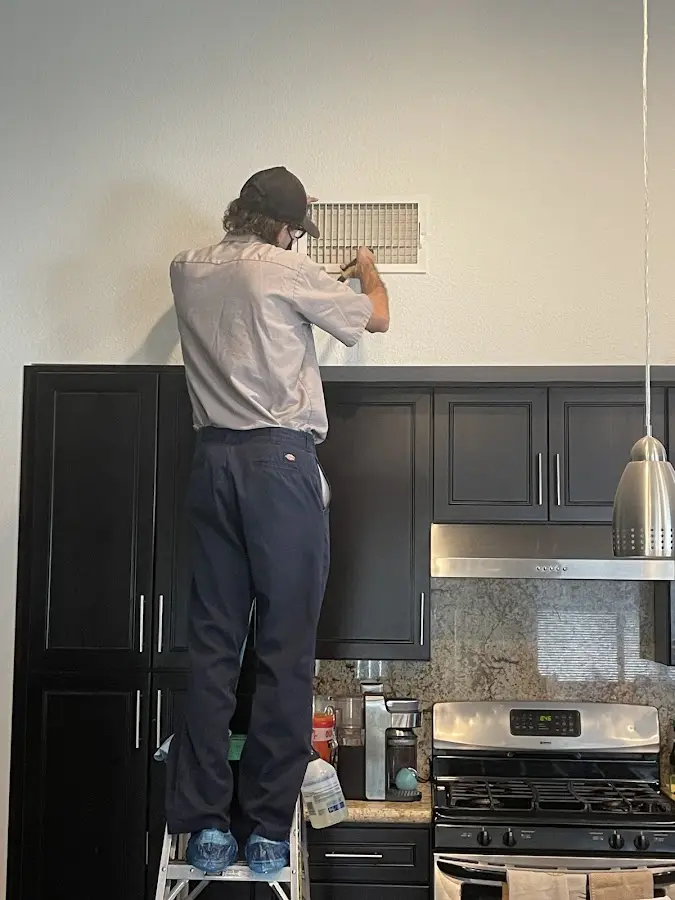 Technician inspecting an air vent during HVAC service in Piedmont